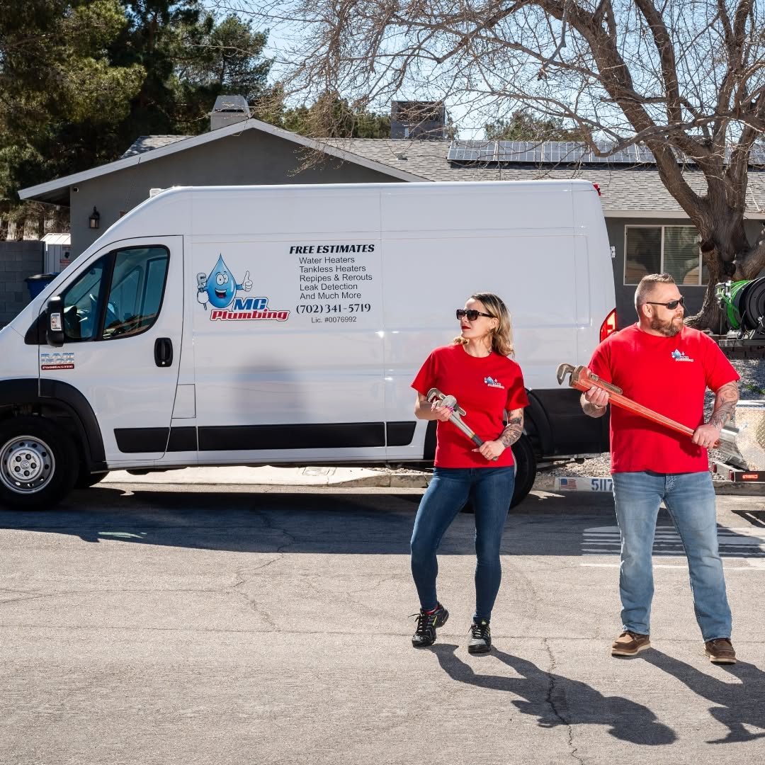 Two MC Plumbing crew members in red company shirts holding pipe wrenches beside an MC Plumbing van lettered with free estimates, (702) 341-5719 and Lic. #0076992.
