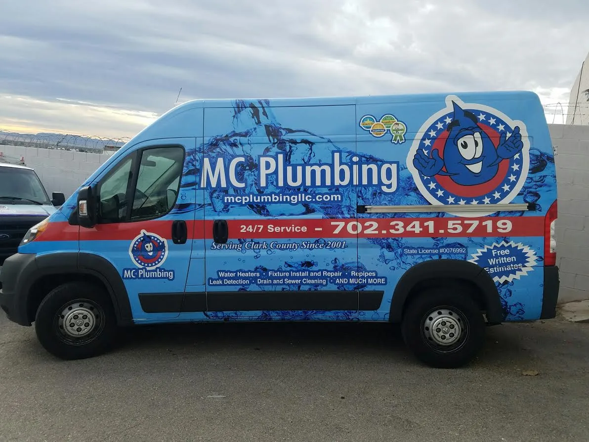 The blue MC Plumbing van with its name and phone number on the wrap.