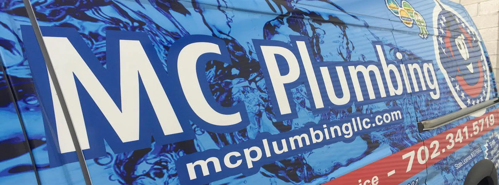 Close-up of the MC Plumbing van wrap advertising water, gas and sewer service across Clark County: the name, mcplumbingllc.com and 702.341.5719.