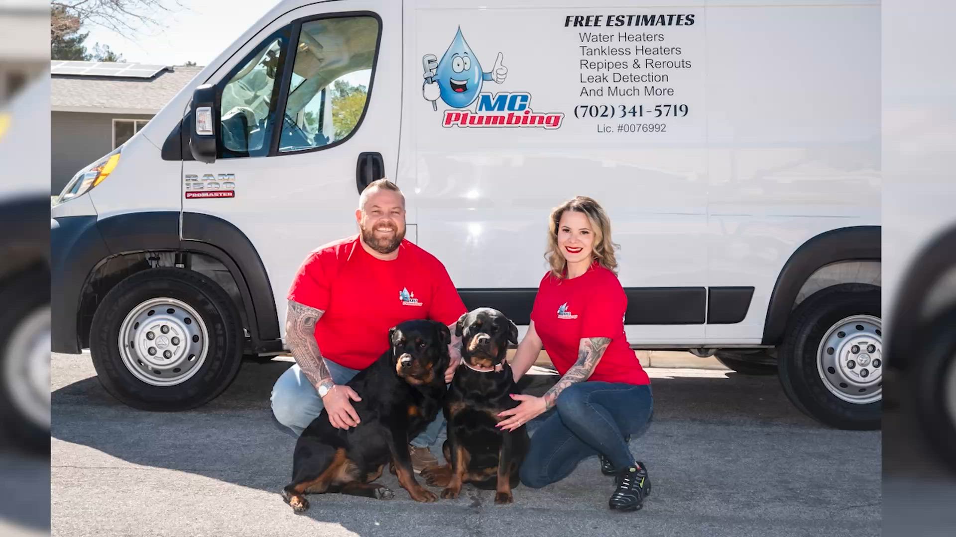 Two MC Plumbing crew members in red company shirts kneeling with two Rottweilers in front of the van lettered Free Estimates and Lic. #0076992.